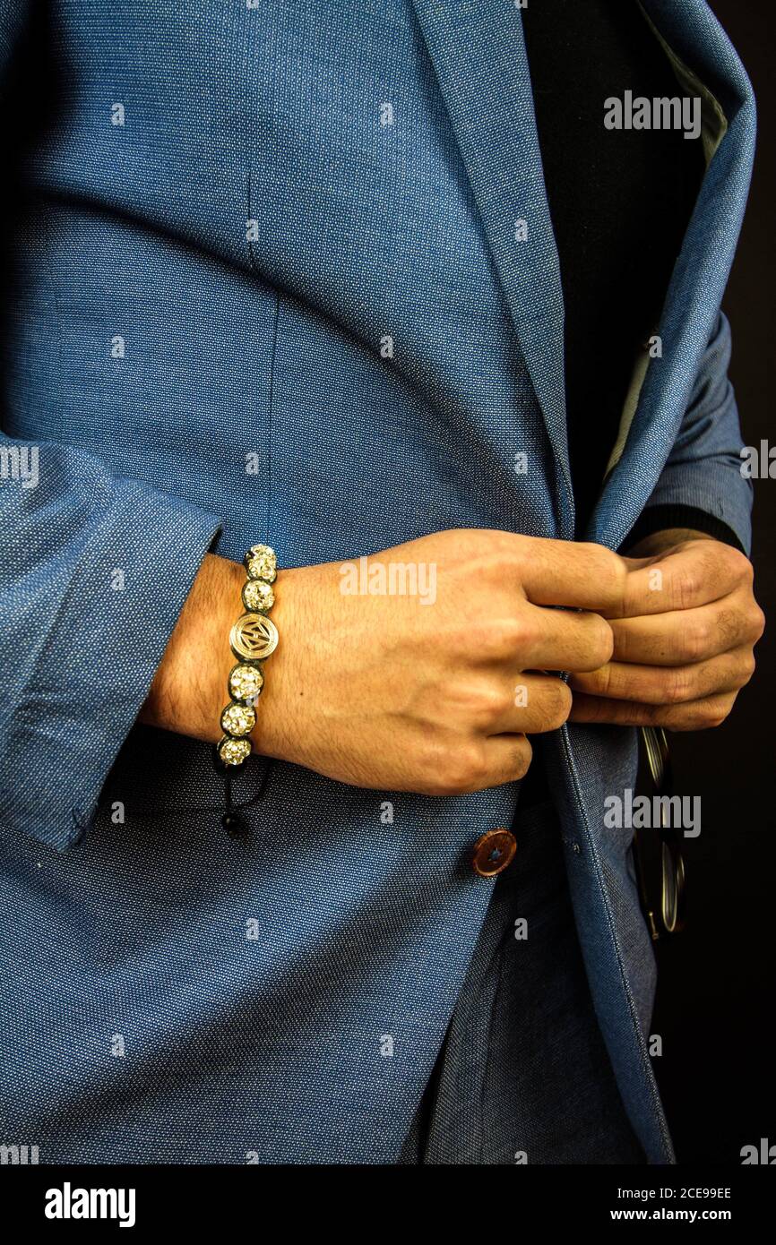 Plan vertical d'un homme en costume portant un magnifique bracelet en pierres Banque D'Images