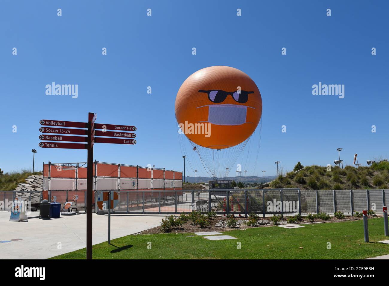 IRVINE, CALIFORNIE - 30 AOÛT 2020 : le ballon Orange County Great Park avec masque COVID-19 et lunettes de soleil se trouve à la gare. Banque D'Images