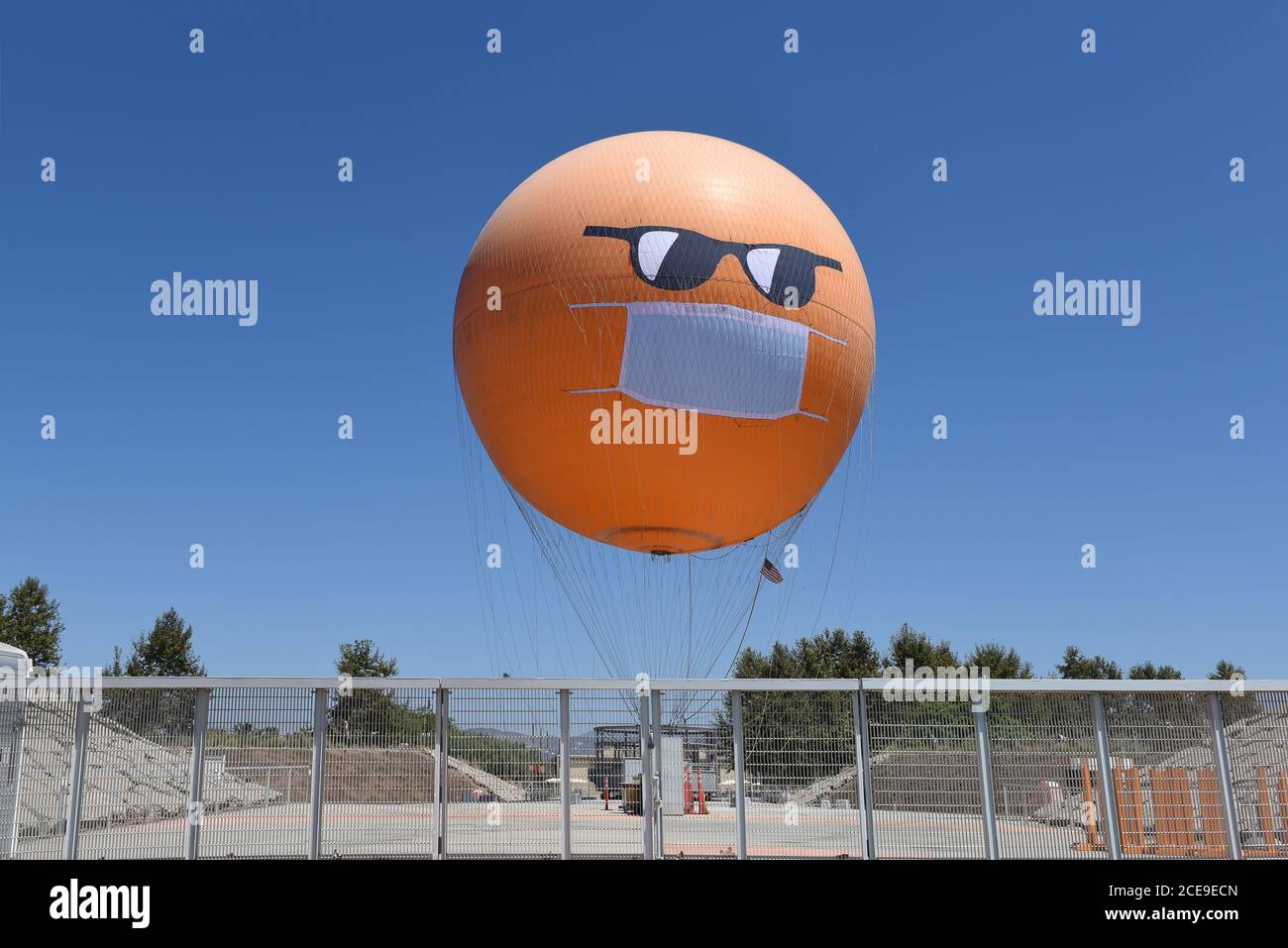 IRVINE, CALIFORNIE - 30 AOÛT 2020 : le grand parc de l'Orange County Balloon sport un masque COVID-19 et des lunettes de soleil pour rappeler aux visiteurs le besoin Banque D'Images