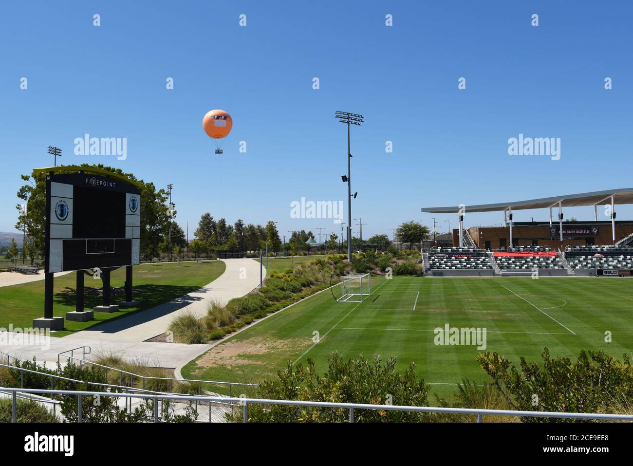 IRVINE, CALIFORNIE - 30 AOÛT 2020: Le Orange County Great Park ballon et stade de football sportif un masque COVID-19 et des lunettes de soleil pour rappeler la visite Banque D'Images