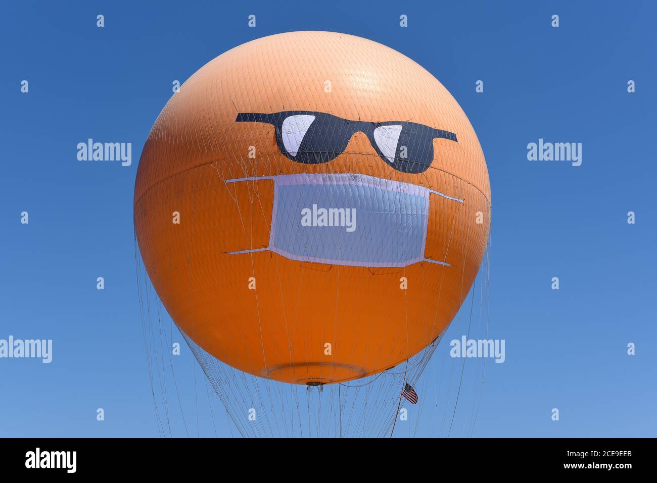 IRVINE, CALIFORNIE - 30 AOÛT 2020 : le grand parc de l'Orange County Balloon sport un masque COVID-19 et des lunettes de soleil pour rappeler aux visiteurs le besoin Banque D'Images