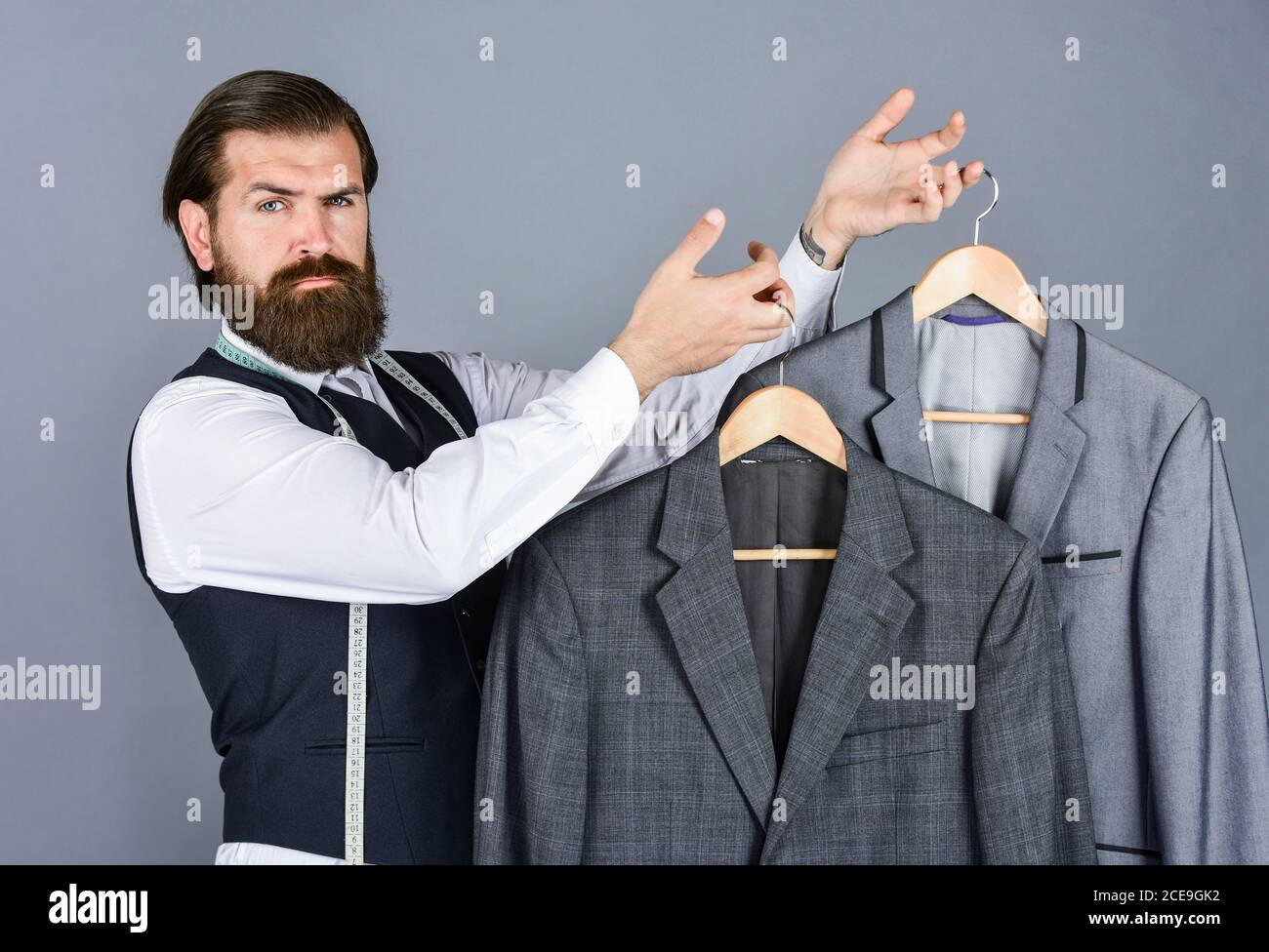 Un homme d'affaires élégant sur mesure dans un espace de travail. Studio de  design de mode. Créateur de mode pour homme. L'homme commande un costume  d'affaires posé à l'intérieur. Prêt à réaliser