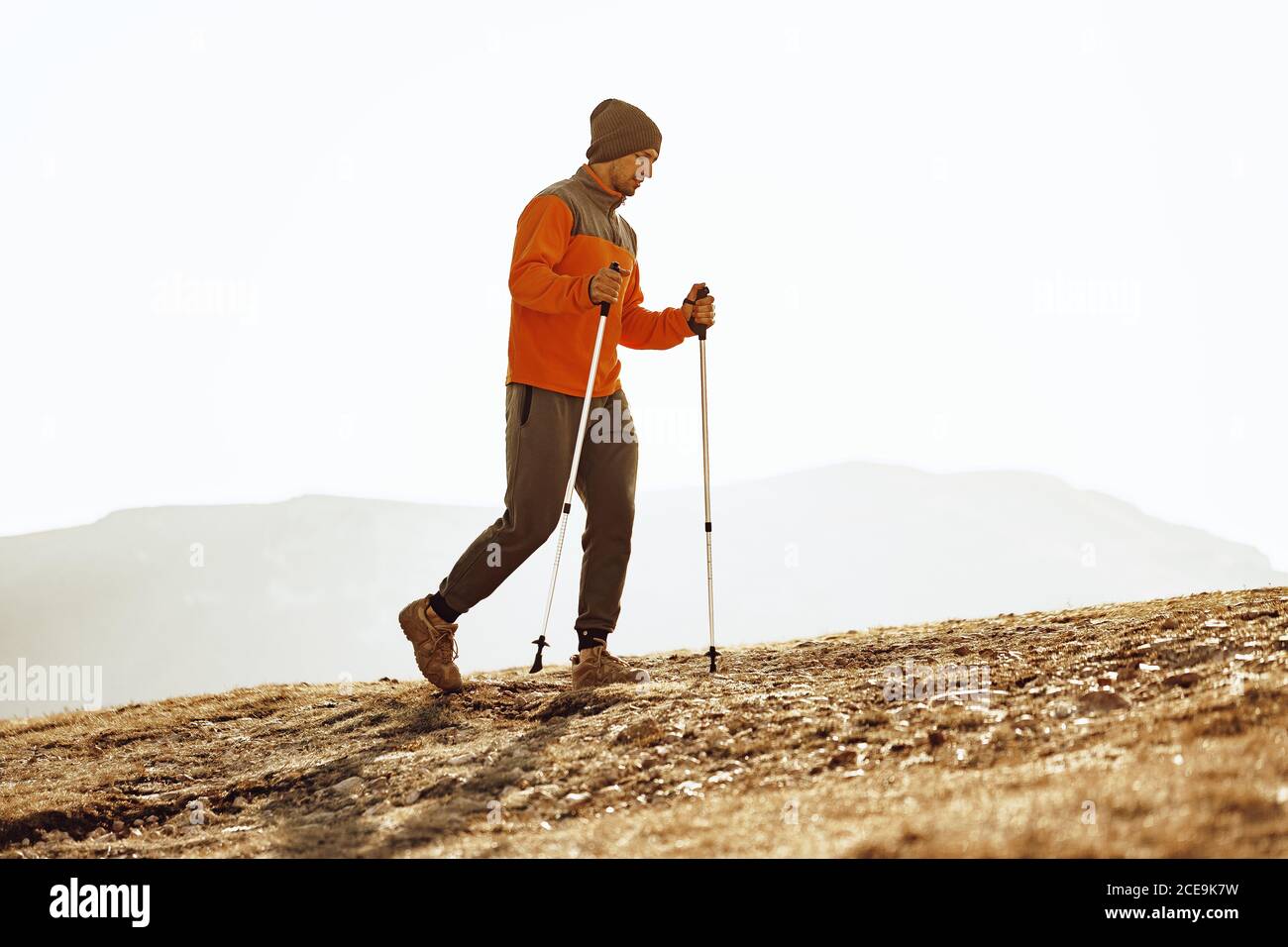 Homme voyageur avec des bâtons de trekking en haut de la montagne Banque D'Images