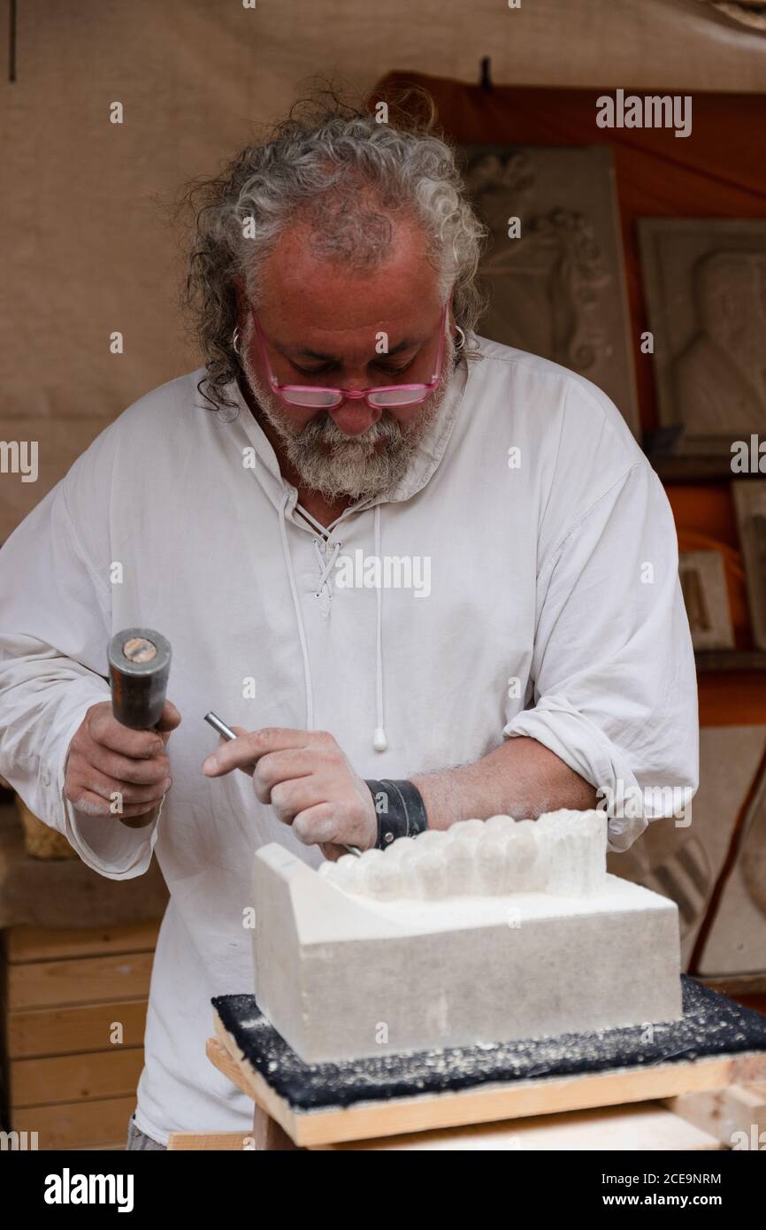 MONTBLANCH, ESPAGNE - 28 AVRIL 2018 : le vieil homme fait une sculpture de marbre de façon traditionnelle à la fête de la semaine médiévale de Montblanc Banque D'Images