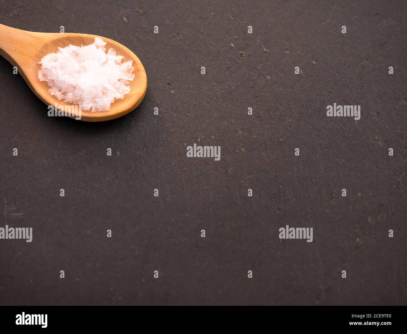 Cuillère en bois avec fleur de sel sur une plaque en ardoise flocons Banque D'Images