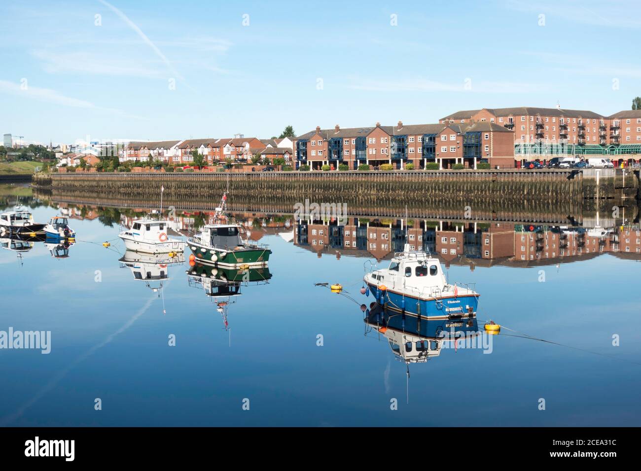 Réflexions de bateaux amarrés dans la rivière Tyne et des appartements à St Peter's Marina, Newcastle upon Tyne, nord-est de l'Angleterre, Royaume-Uni Banque D'Images