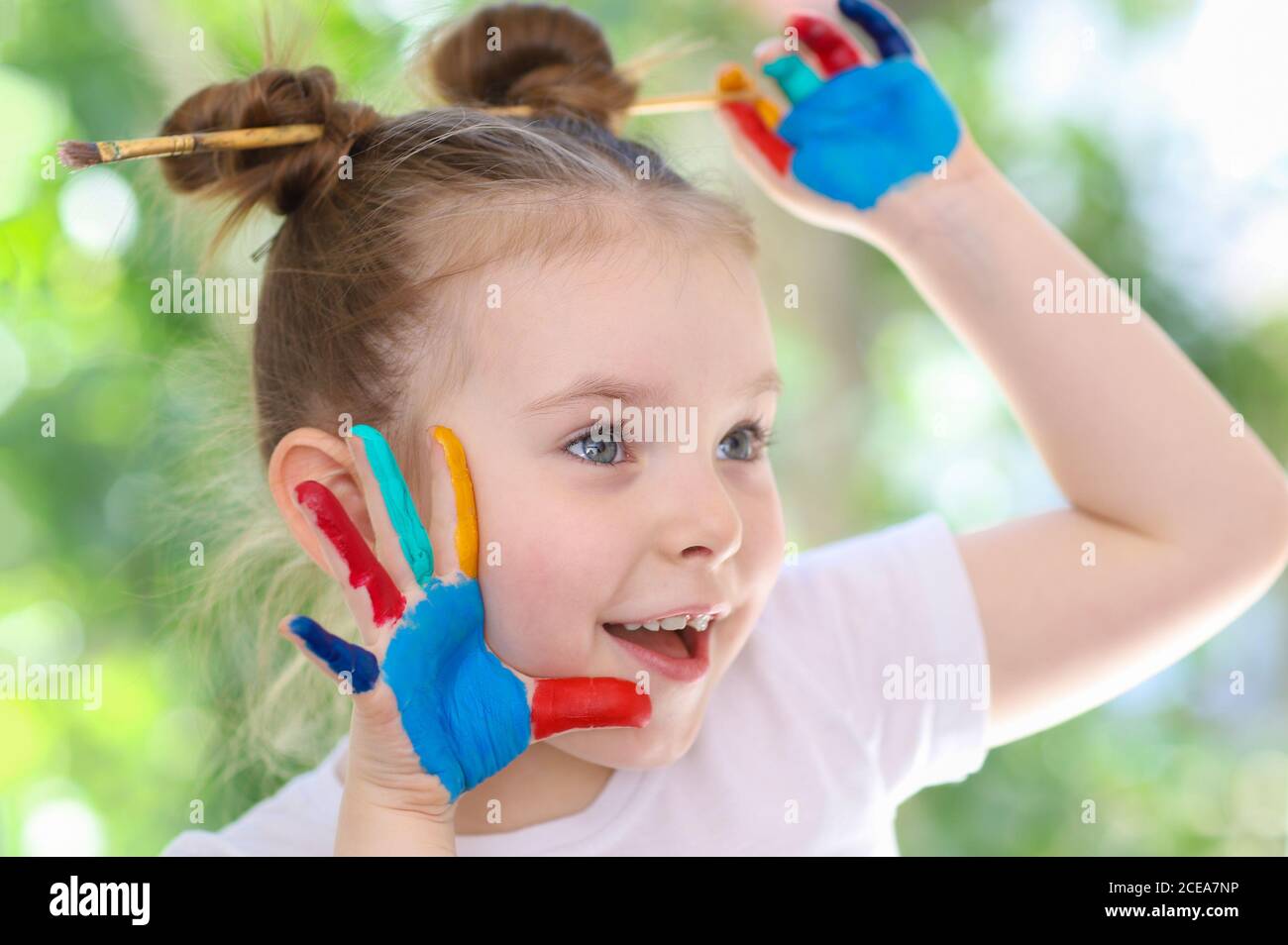 Drôle petite fille mignonne avec ses mains tachées dans la peinture. Le concept de la créativité des enfants. Photo de haute qualité Banque D'Images