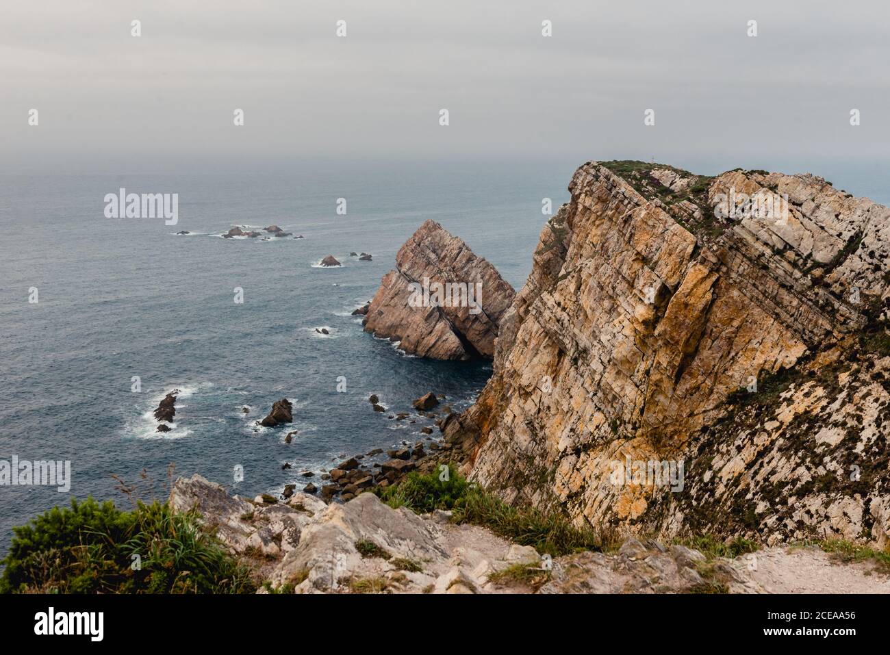 Falaise rugueuse près de la mer le jour couvert Banque D'Images