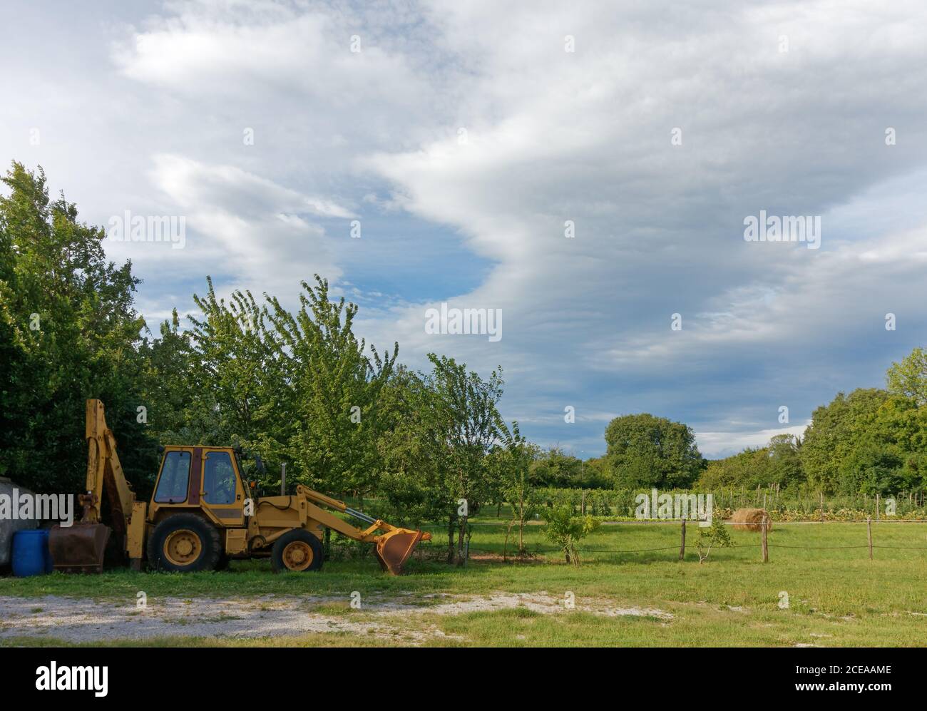Tracteur jaune stationné en marge d'une zone cultivée Banque D'Images
