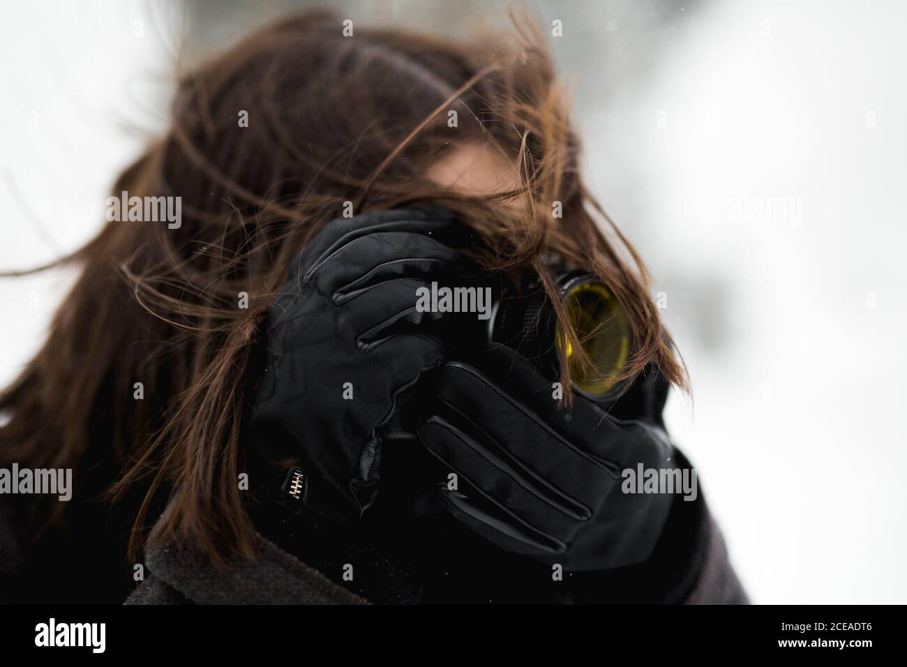 anonyme femme en gants chauds utilisant un appareil photo professionnel à prendre photos de la journée hivernale venteuse Banque D'Images