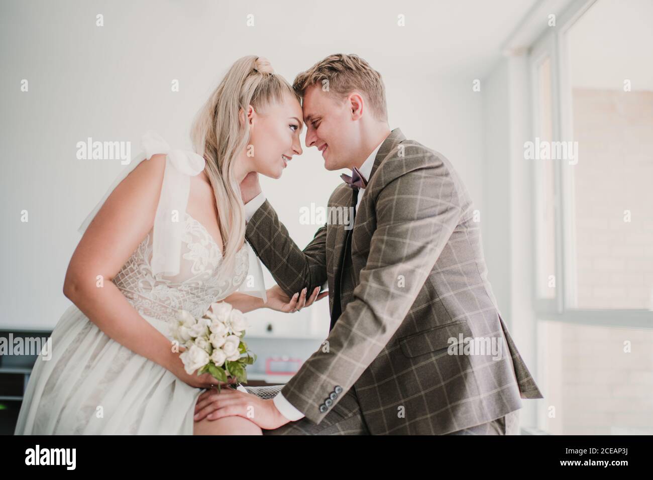 Vue latérale d'un couple heureux et marié qui se couchait et regarde les uns les autres à la maison Banque D'Images