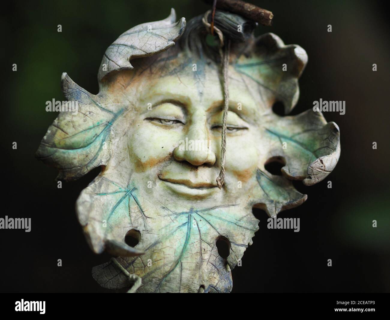 Green Man décoration suspendue dans les bois à Badby, Northamptonshire Banque D'Images