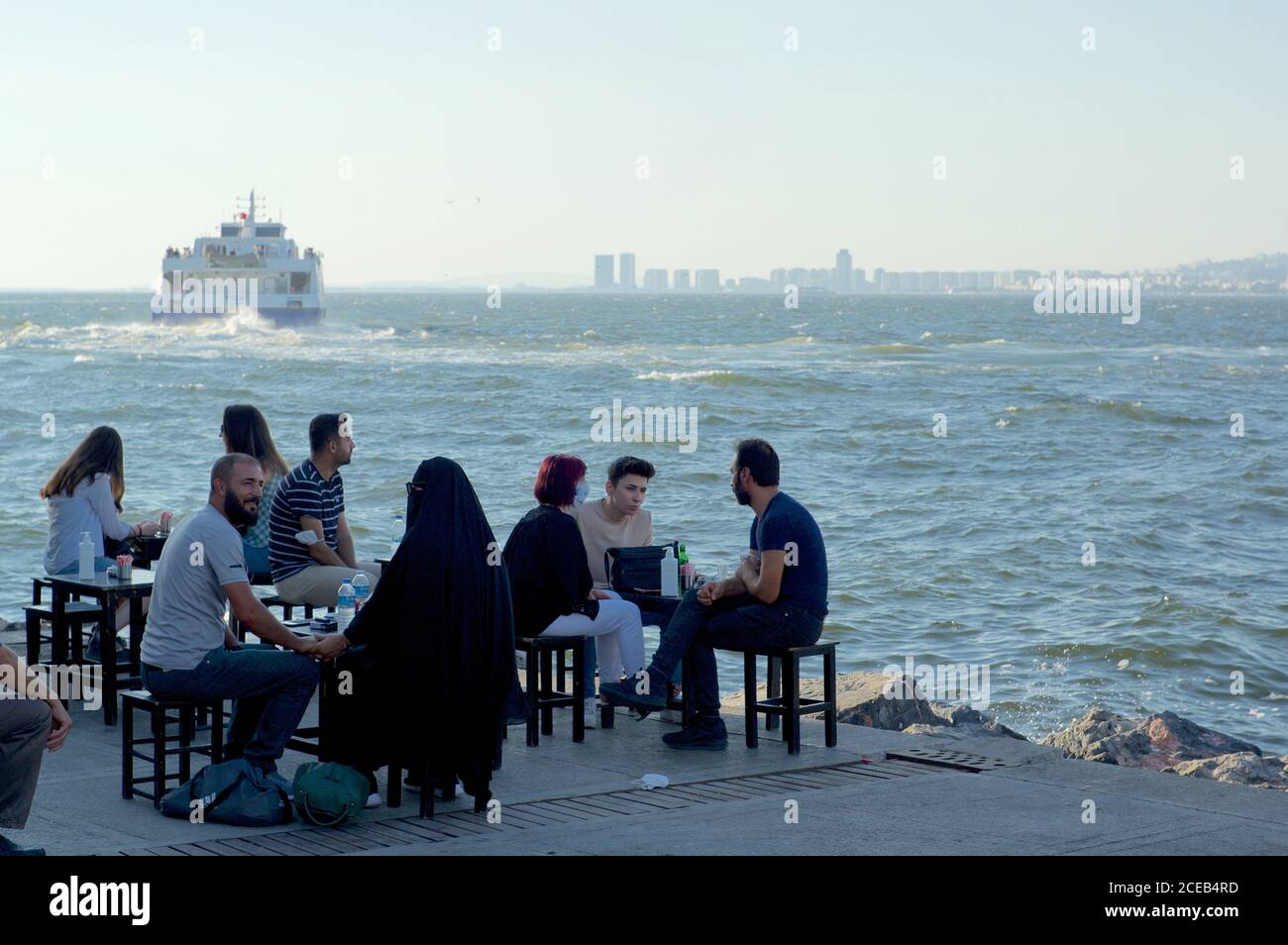 Les habitants de la région s'assoient et boivent du thé au quai de la gare maritime de Konak, Izmir, Turquie Banque D'Images