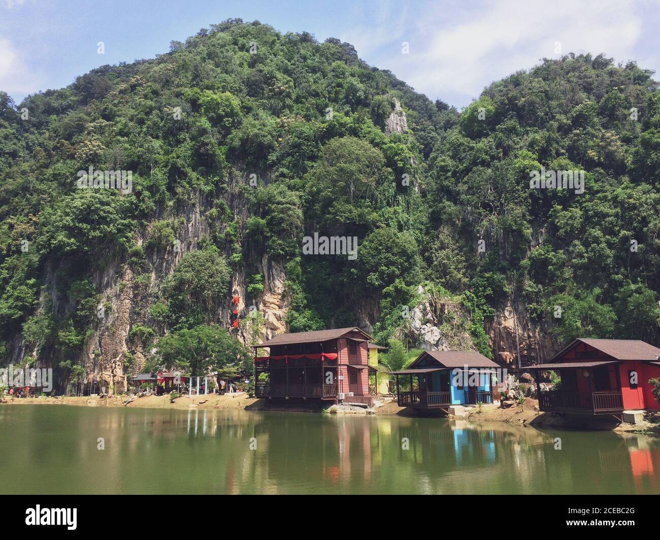 Magnifique monument entouré de montagnes et de vert face au lac clairement réfléchissant à Ipoh, Malaisie. Banque D'Images