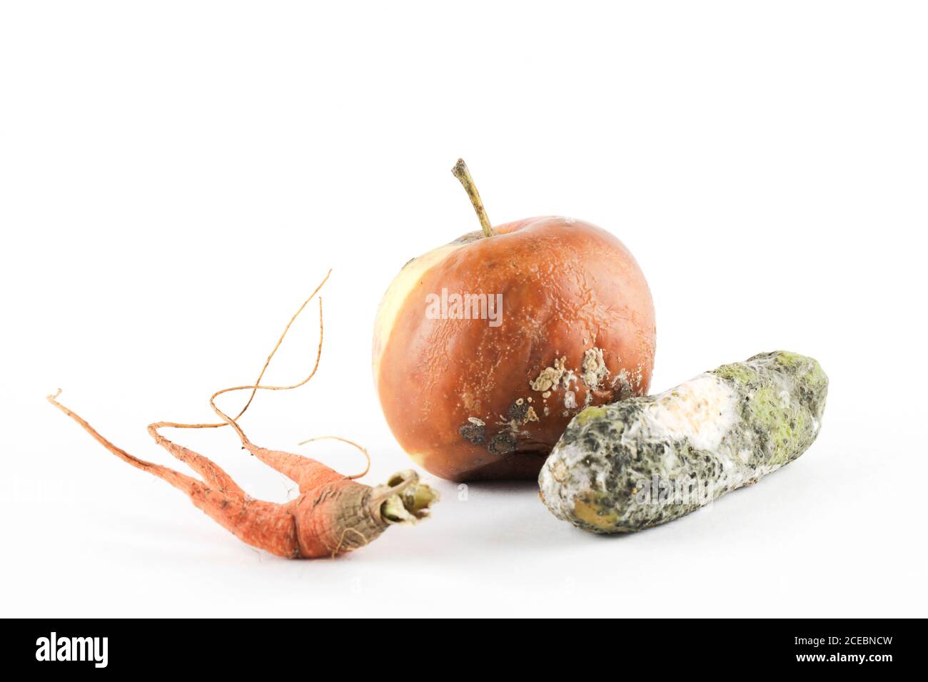 pomme pourrie, concombre, carotte sur fond blanc. problème de faim dans le monde. concept de surconsommation. vue de dessus espace de copie Banque D'Images