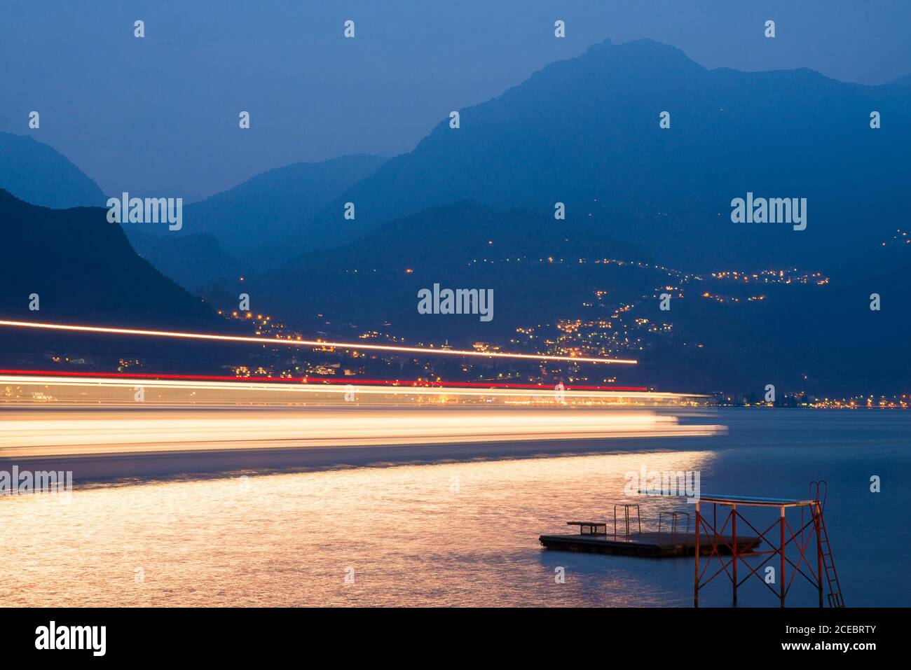 Motion Speed lumière du passage du ferry sur le lac de Côme. Italie. Traînées de lumière colorées avec effet flou de mouvement. Exposition longue durée. Banque D'Images Motion Speed lumière du passage du ferry sur le lac de Côme. Italie. Traînées de lumière colorées avec effet flou de mouvement. Exposition longue durée. Banque D'Images