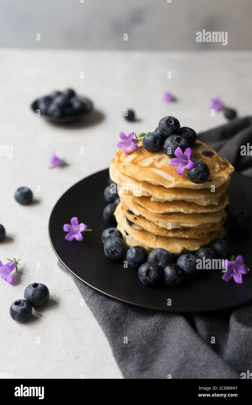 Pile de crumets appétissants avec des fleurs de myrtille et de myrtille décoration sur une table Banque D'Images