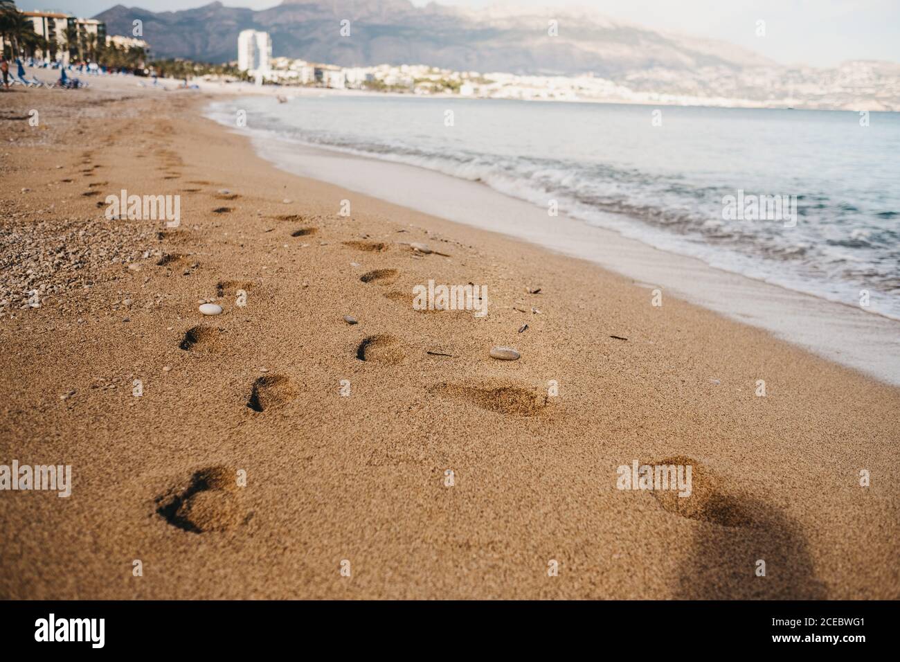 Traces de pieds humains sur du sable humide près de la mer d'Altea, Espagne Banque D'Images