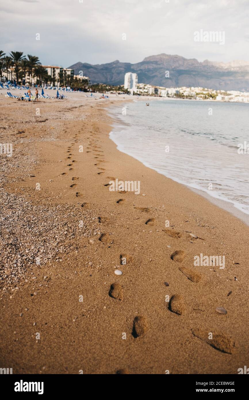 Traces de pieds humains sur du sable humide près de la mer d'Altea, Espagne Banque D'Images