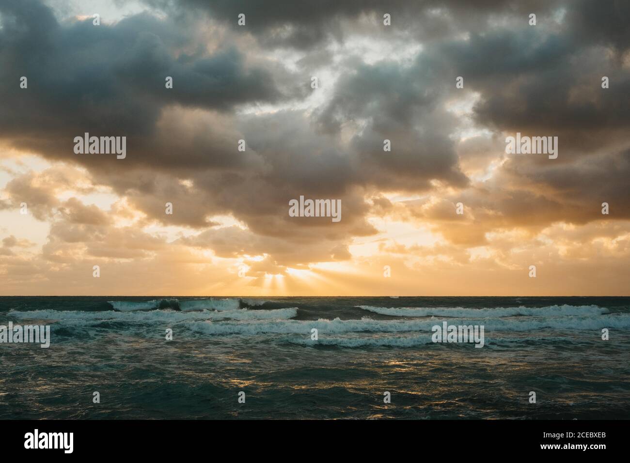 Un soleil éclatant se couche sur la mer, derrière d'épais nuages Miami Banque D'Images