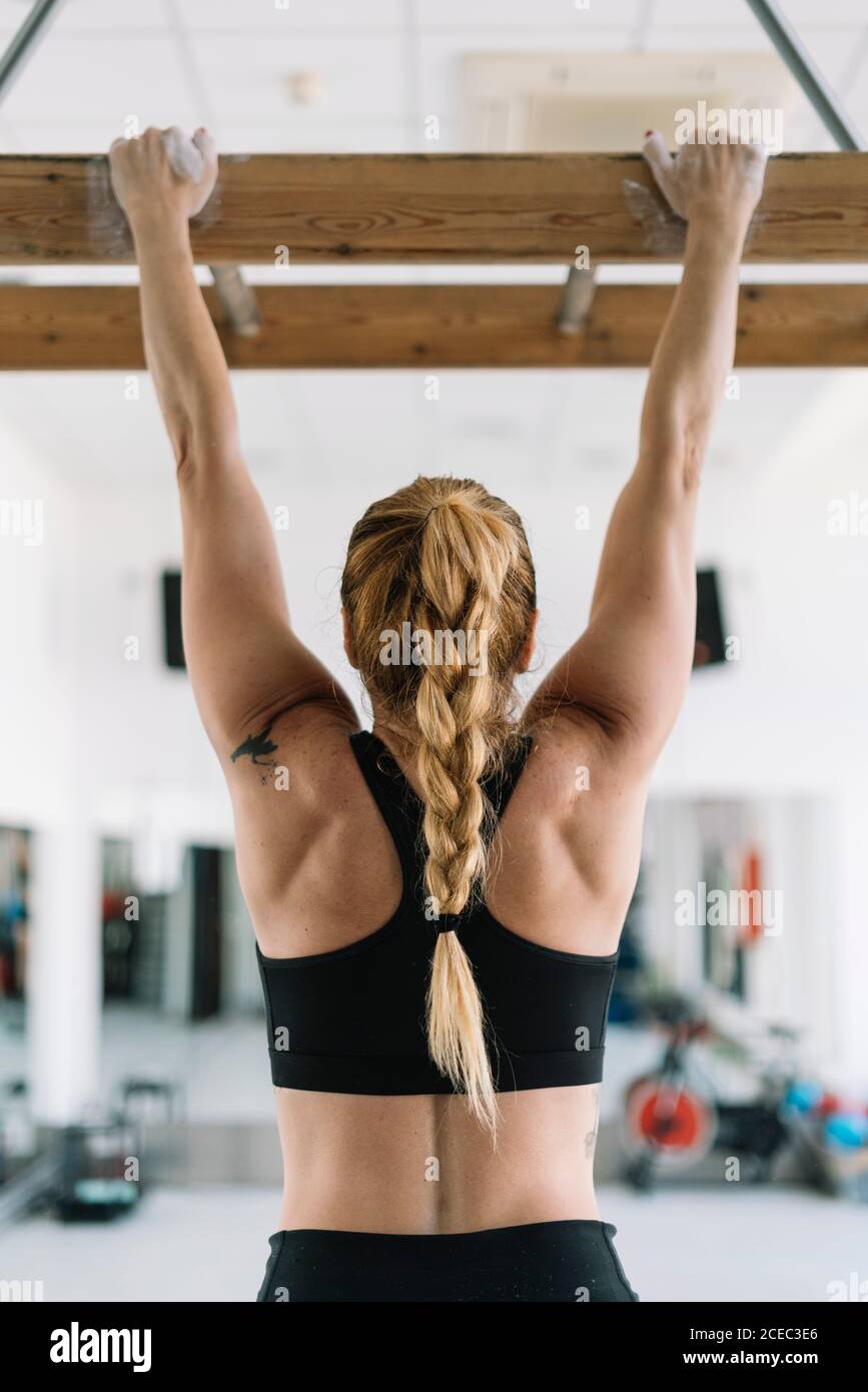 Vue arriere d une femme forte dans des vetements de sport accrochee a une planche en bois dans la salle de gym et de se tirer vers le haut Photo Stock Alamy