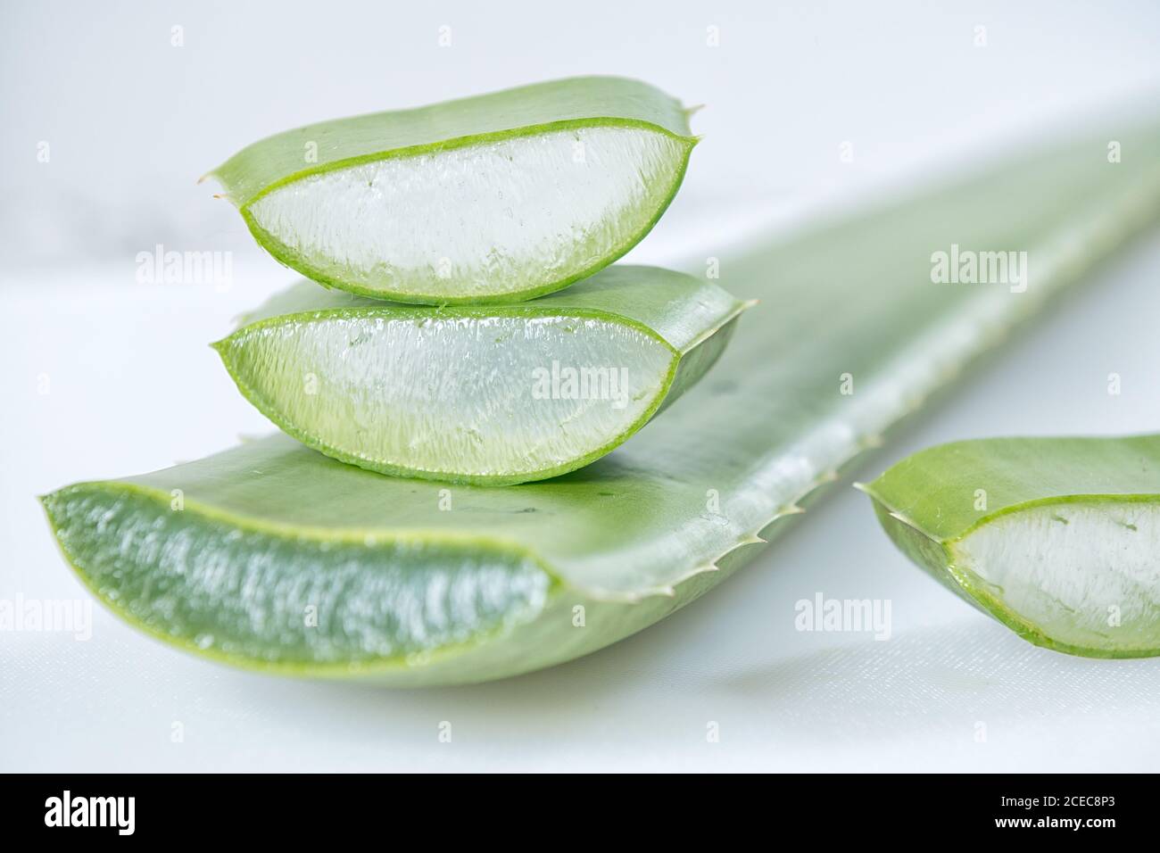 Morceaux de Vera d'aloès vert frais avec chair blanche sur fond clair. Banque D'Images