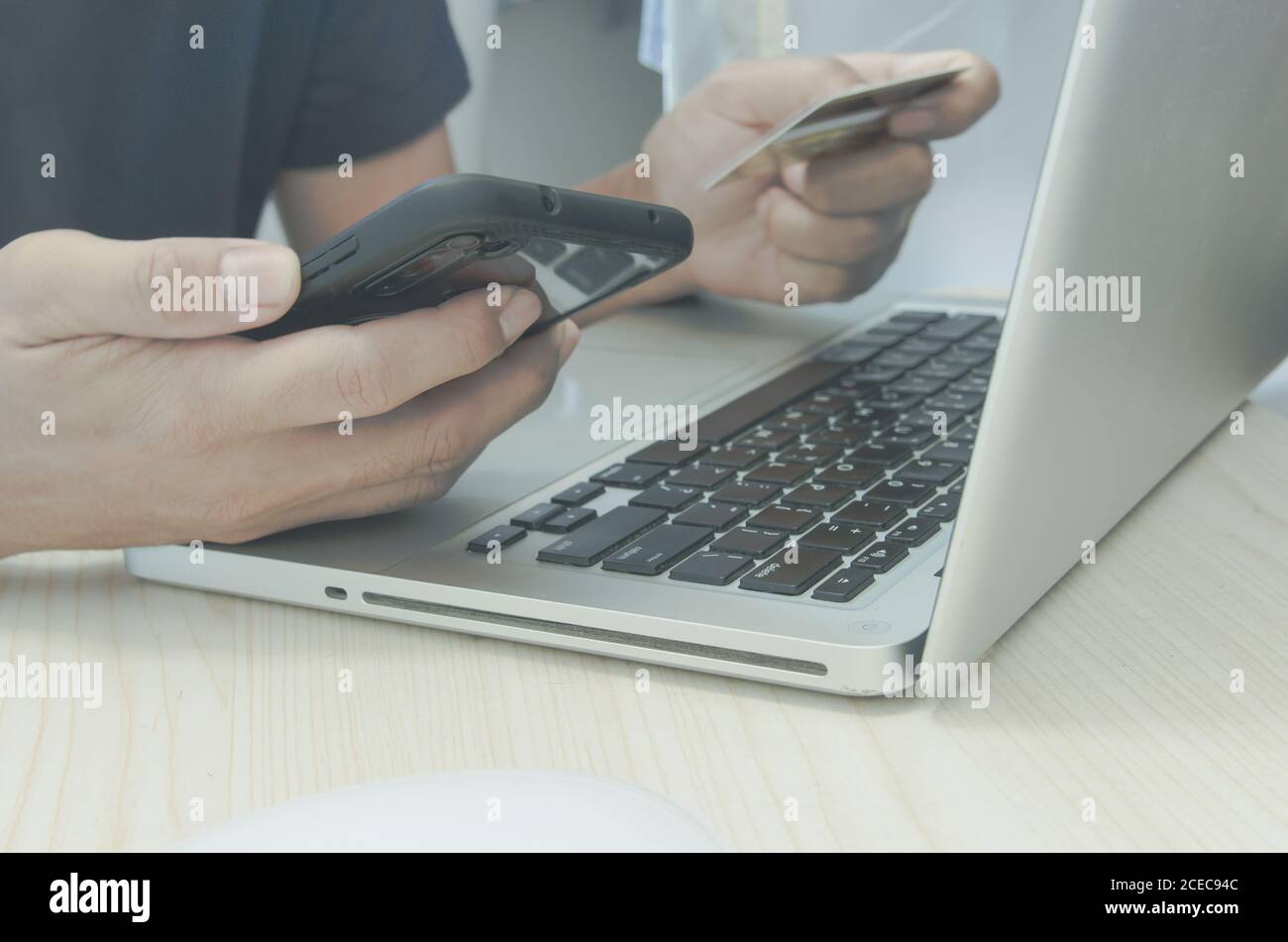Man Shopping en ligne à l'aide d'un ordinateur portable avec une carte de crédit.mains tenant une carte de crédit et un smartphone. Banque D'Images