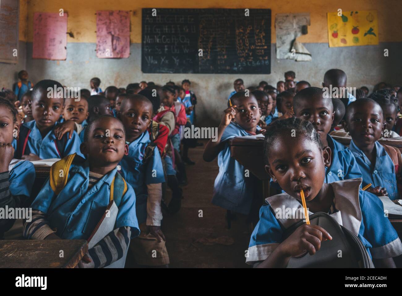 CAMEROUN - AFRIQUE - 5 AVRIL 2018: Groupe d'élèves africains assis avec des crayons en classe et regardant un appareil photo. Banque D'Images