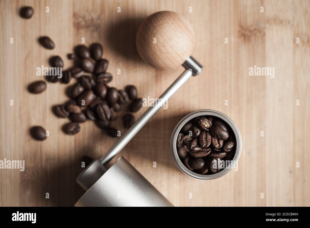 Le moulin à café manuel et les grains de café torréfiés sont sur un bureau en bois, une photo à plat avec une mise au point douce Banque D'Images