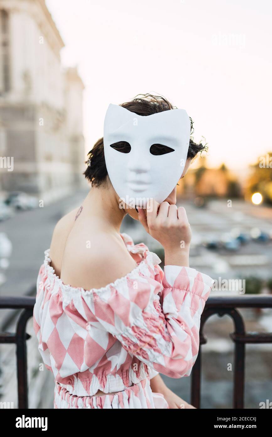 Anonyme jeune femme portant un costume de théâtre et un masque blanc en  agissant dans la rue de la ville Photo Stock - Alamy