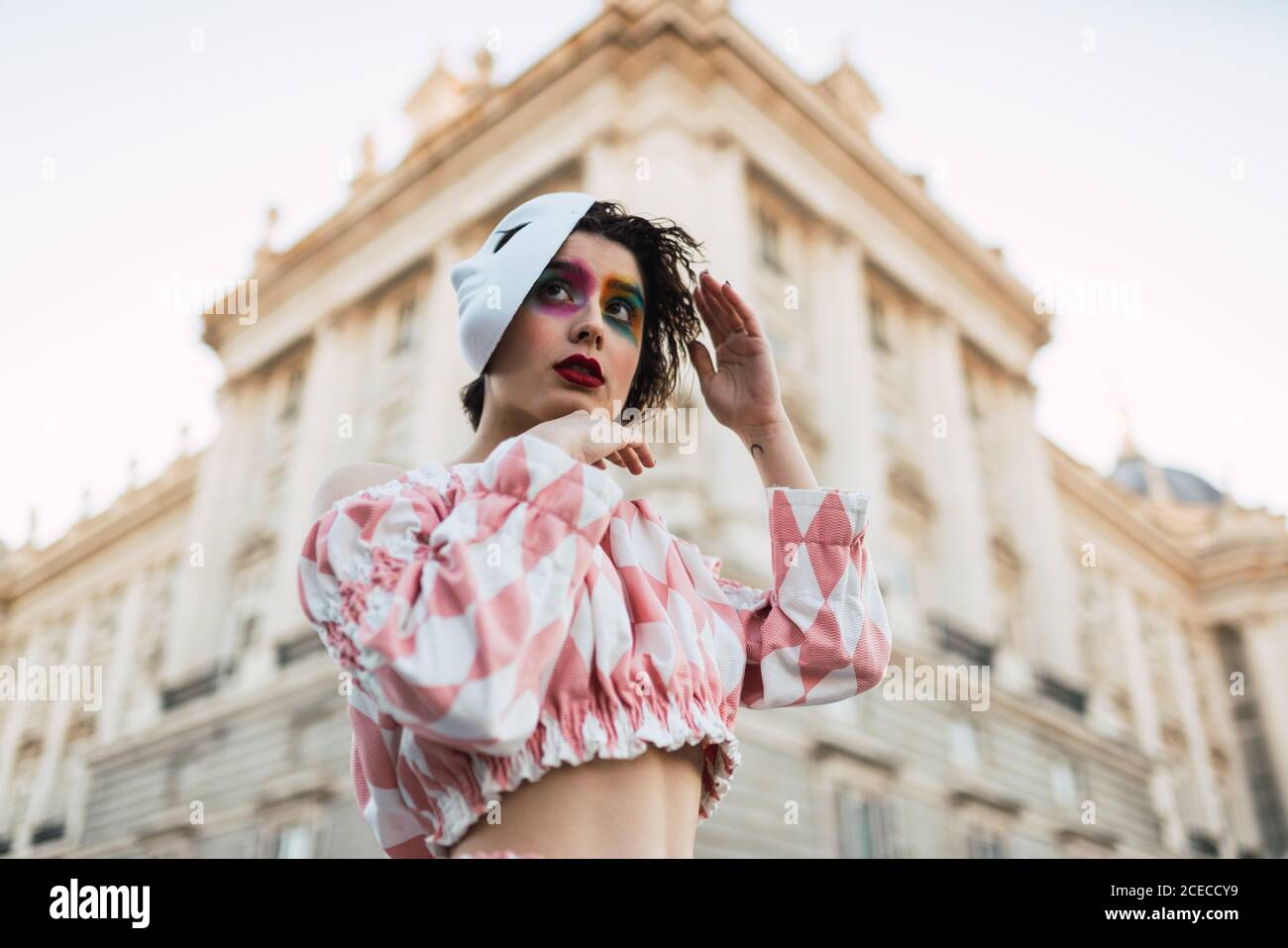 Jeune femme avec costume de théâtre et masque blanc en agissant dans la rue de la ville Banque D'Images