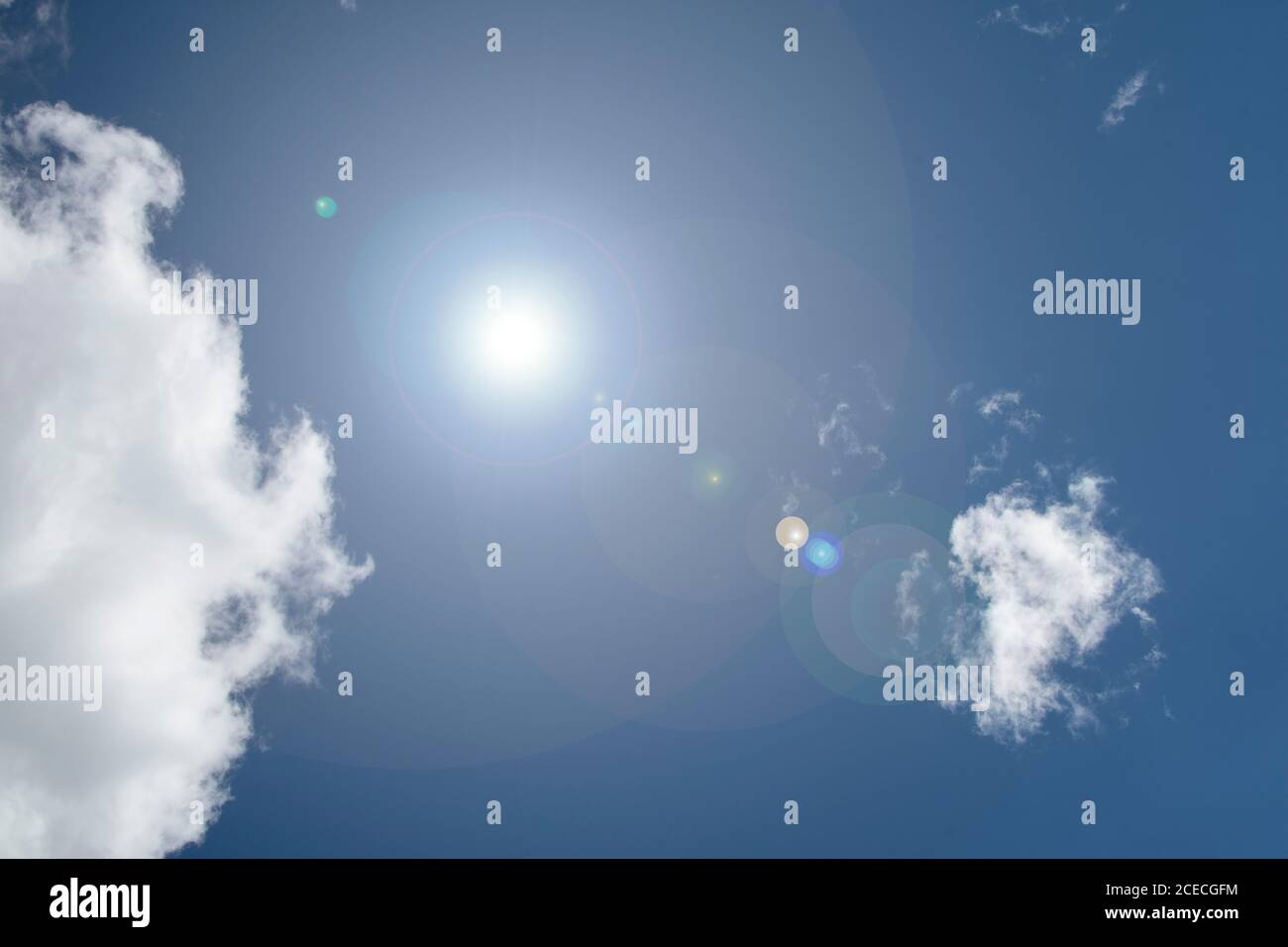 Nuages dans le ciel bleu avec la lumière de l'objectif Banque D'Images