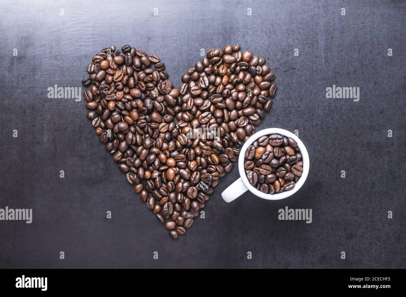 Grains de café avec tasse sur fond sombre, en forme de coeur, gros plan de vie, plat, studio à l'intérieur, j'aime le concept de café Banque D'Images