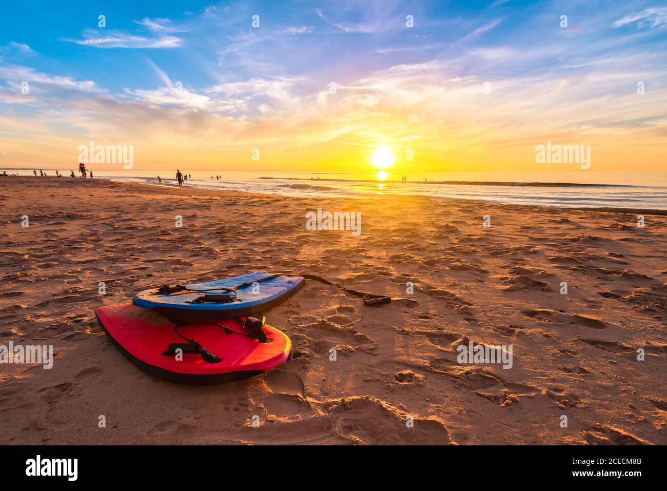 Baignade de planches de bodyboard sur la plage au beau coucher du soleil lors d'une chaude soirée d'été, Australie méridionale Banque D'Images