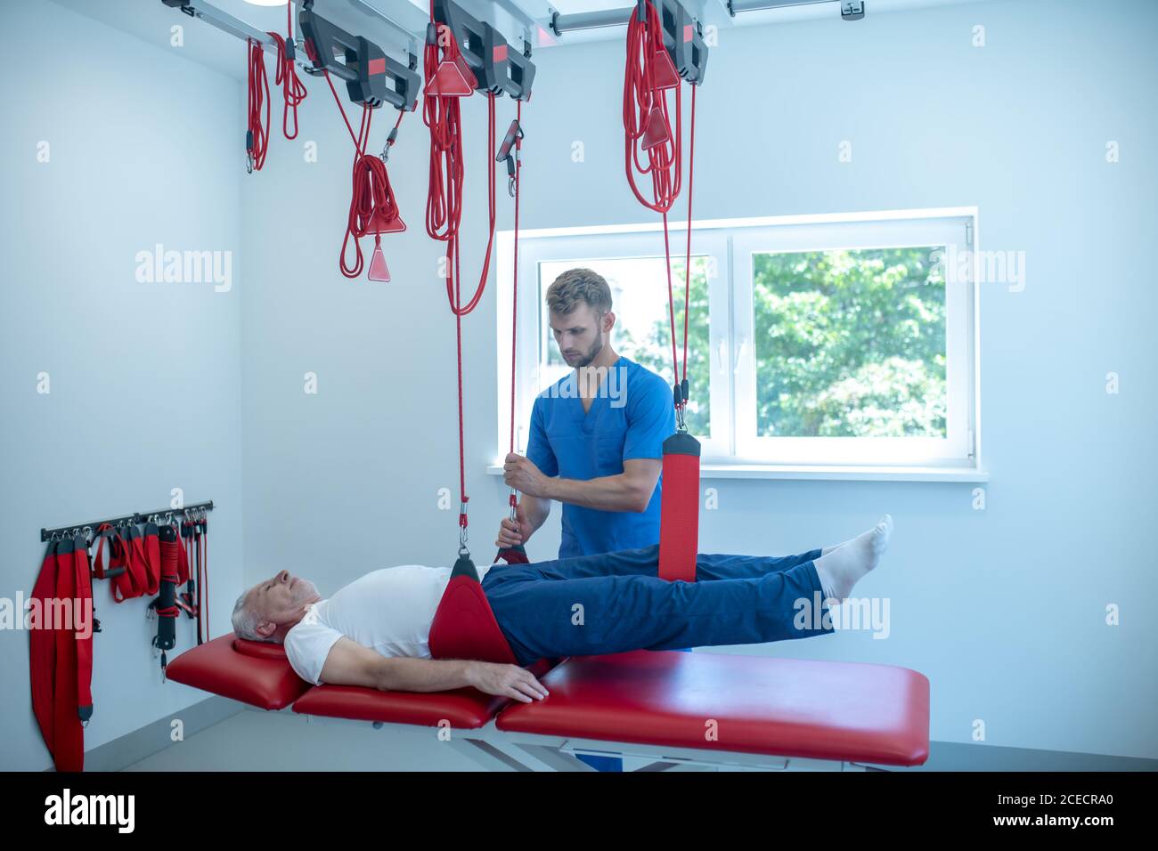 Homme âgé en session d'étirement au centre médical Banque D'Images