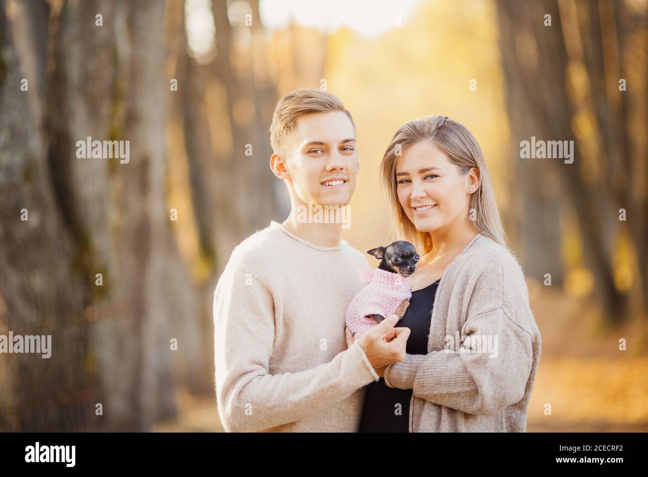 Couple amoureux des câlins chauds et brillants tenant le chien nain dans leurs mains. Concept sans enfants Banque D'Images