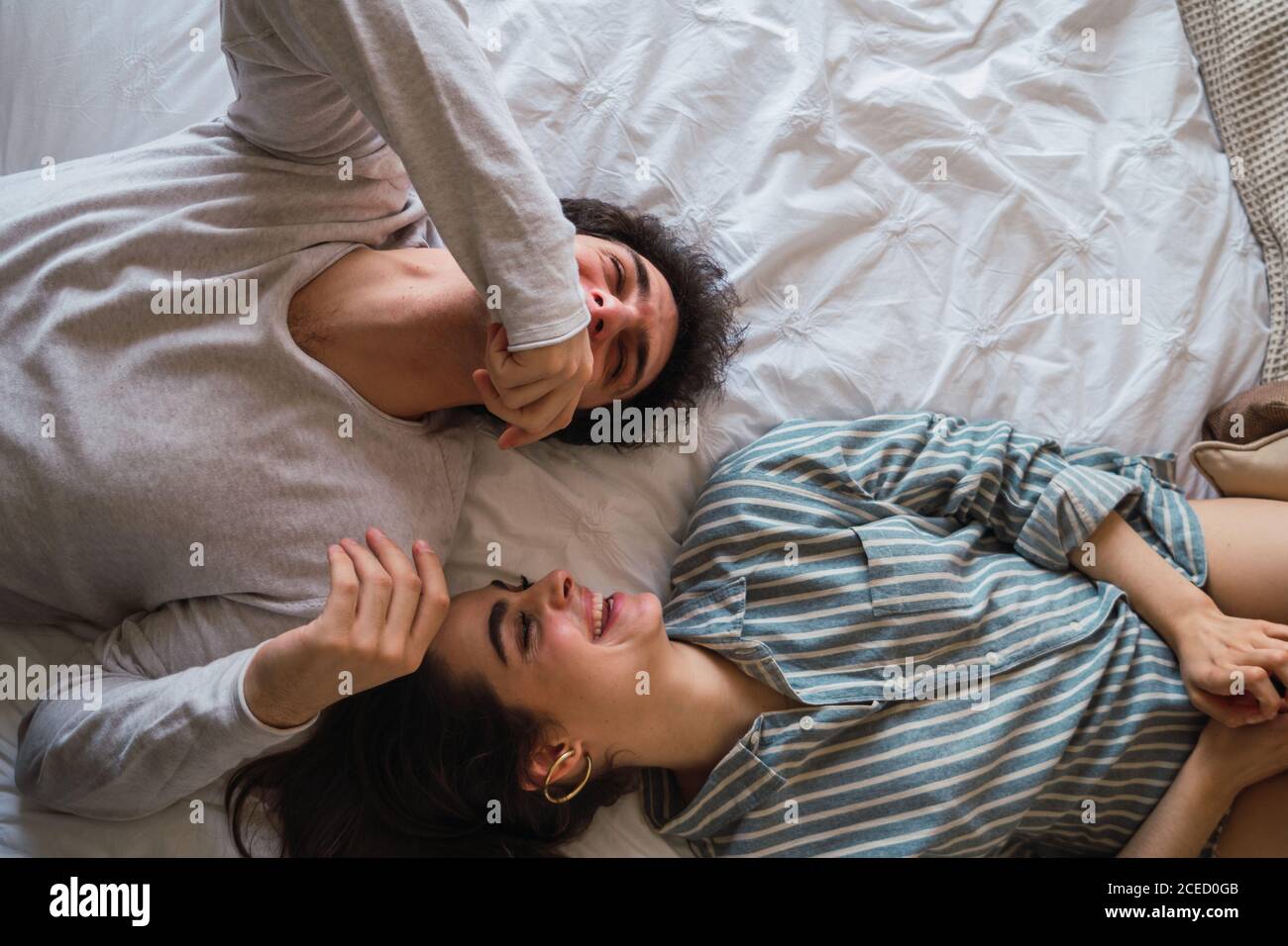 Homme et femme joyeux allongé sur le lit Banque D'Images