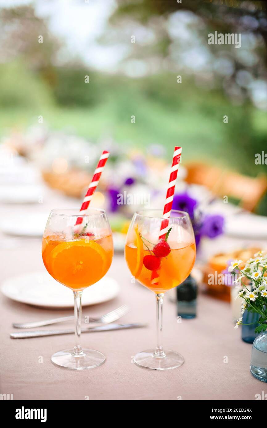 Verres de délicieux apéritif Spritz avec paille table de réception avec  hors-d'œuvre et fleurs fraîches dans le jardin Photo Stock - Alamy