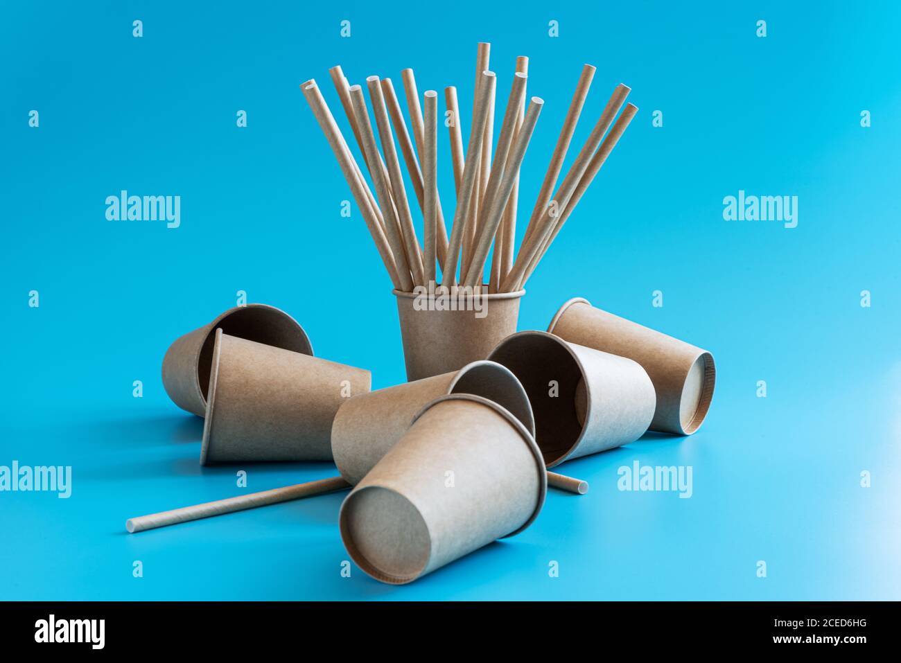 Gobelets jetables en papier brun artisanal avec pailles en papier sur fond bleu. Vaisselle écologique. Passez au concept vert. Thème zéro gaspillage Banque D'Images