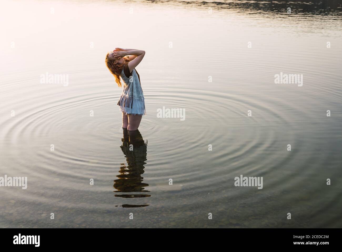 Femme debout dans l'eau claire du lac Banque D'Images