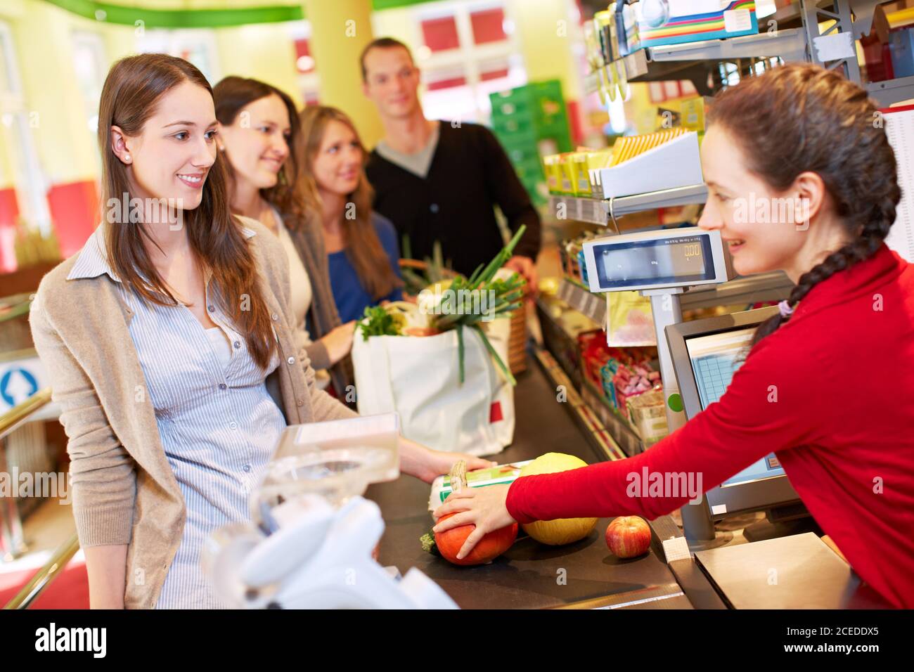 Une jeune femme se tient à la caisse, à la caisse, au supermarché Banque D'Images