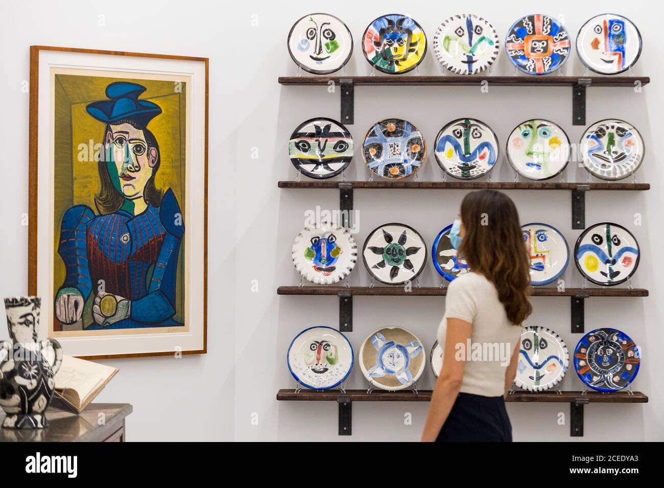 Londres, Royaume-Uni. 1er septembre 2020. Un membre du personnel pose avec (de L à R) 'Femme assise (Dora Maar) [Femme assise (Dora Maar)]', 1955, et 'l'ensemble complet de 20 'plaques de visite', 1963, tous par Pablo Picasso. Avant-première de l'atelier Picasso, une nouvelle exposition recréant le studio de Pablo Picasso à Cannes avec ses dessins, ses gravures, ses céramiques et ses meubles. Le spectacle est à la galerie Bastian à Mayfair du 3 septembre au 31 octobre 2020. Les visiteurs devront porter un masque facial et pratiquer la distanciation sociale. Credit: Stephen Chung / Alamy Live News Banque D'Images