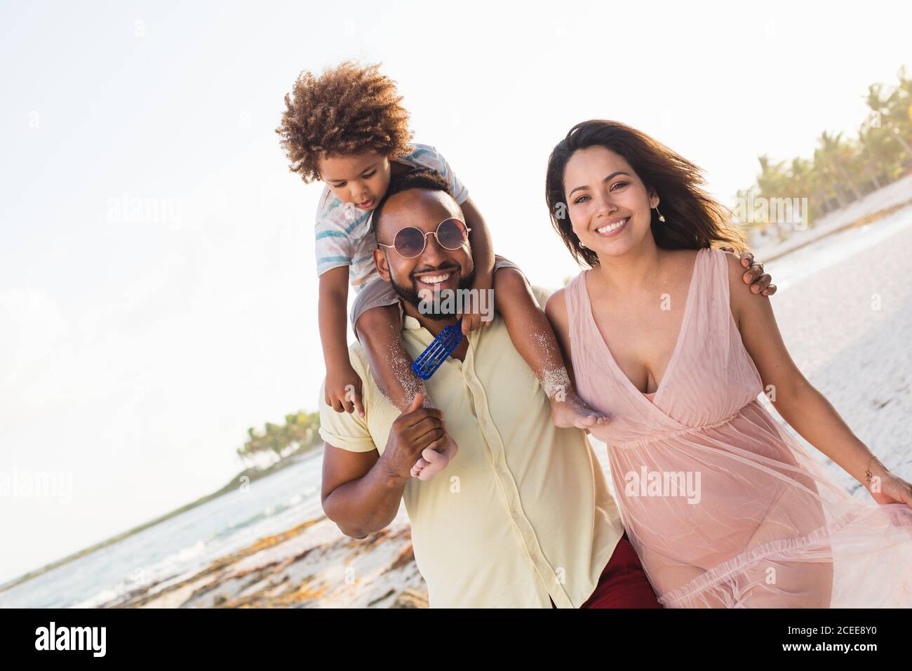 Bonne famille ethnique marchant ensemble sur la plage Banque D'Images