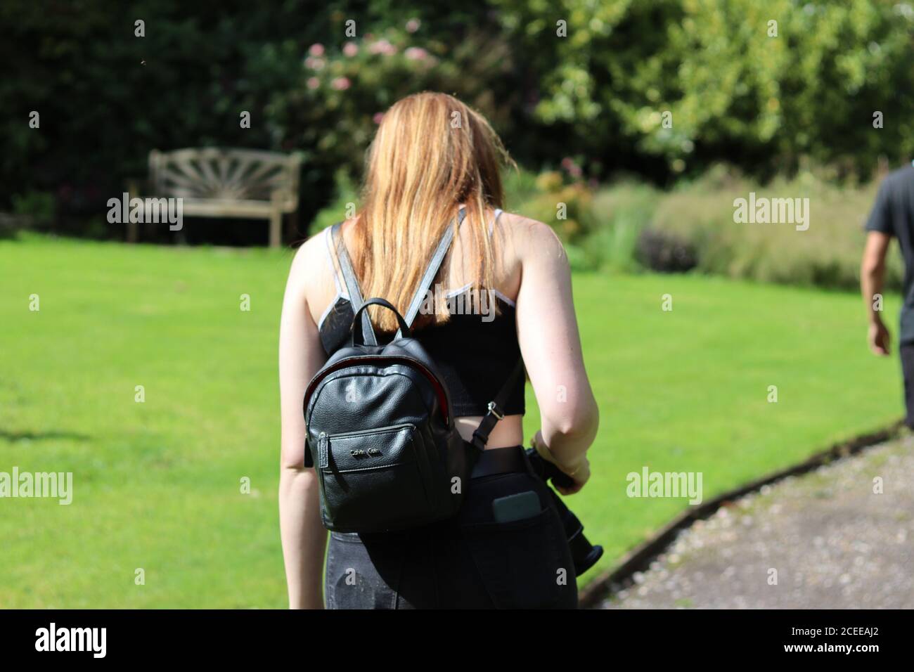 Ginger Woman marchant dans un jardin Banque D'Images