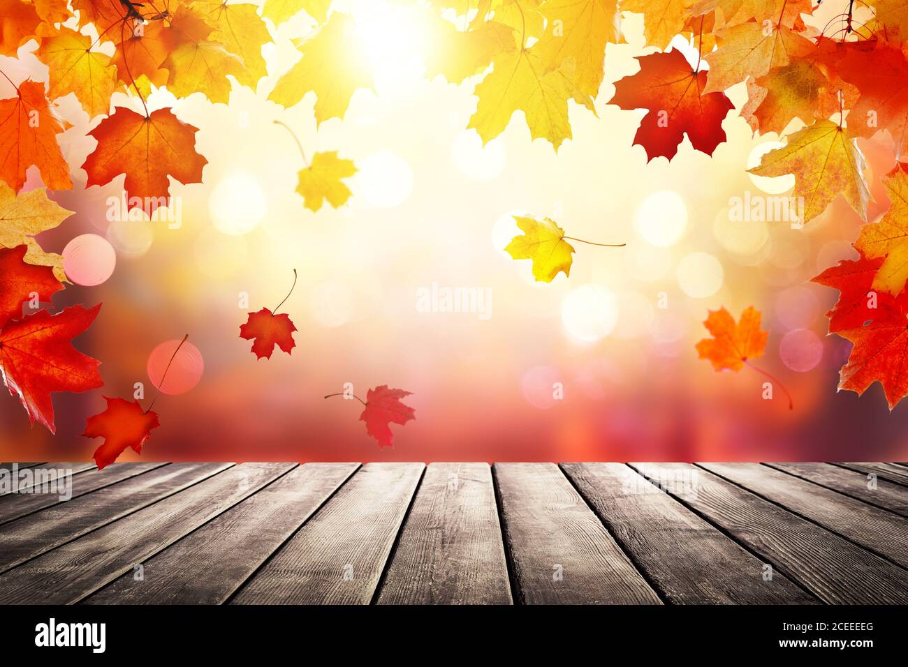 Plateau de table en bois sur fond d'automne flou. Arrière-plan abstrait doré d'automne avec lumière bokeh et feuilles d'automne colorées. Banque D'Images