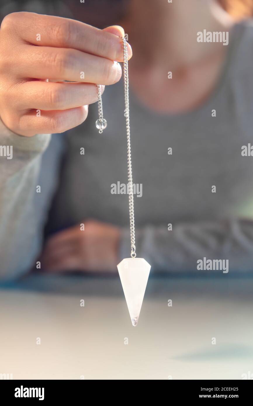 Fortuneteller tient un pendule de cristal, spirituellement libre et ésotérique, de près Banque D'Images