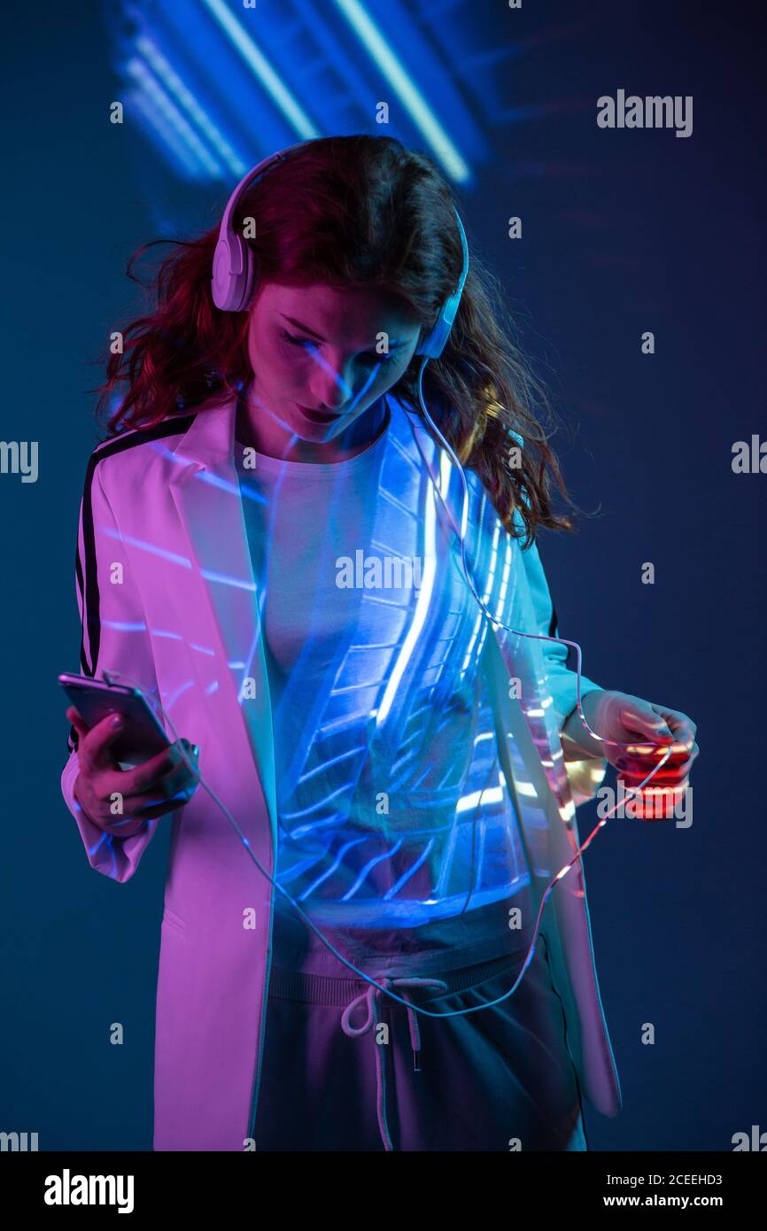 Femme écoutant de la musique et utilisant un smartphone Banque D'Images