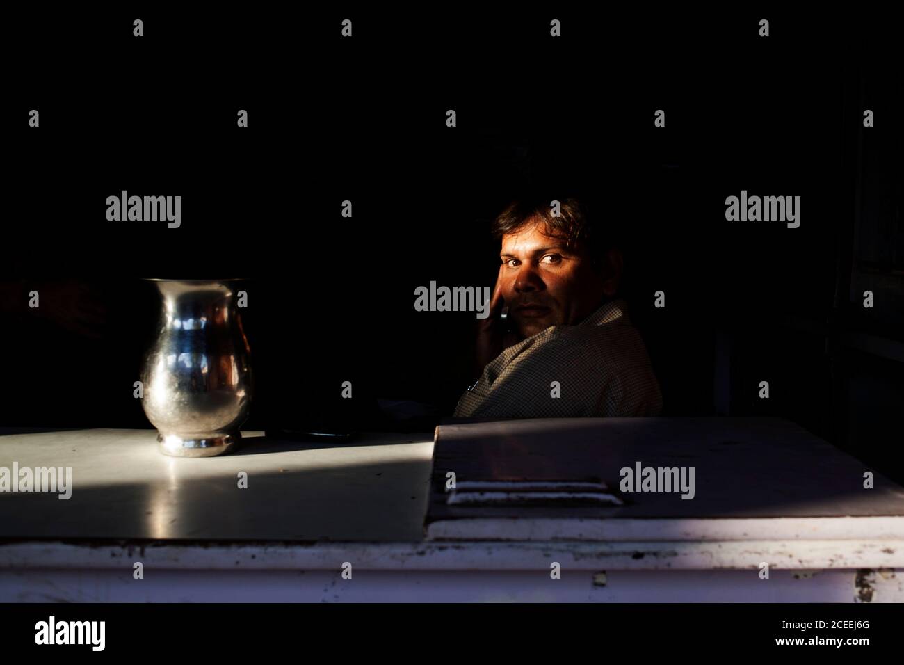 INDE - 3 octobre 2011: Homme en costume assis derrière la table avec pichet et regardant la caméra. Banque D'Images