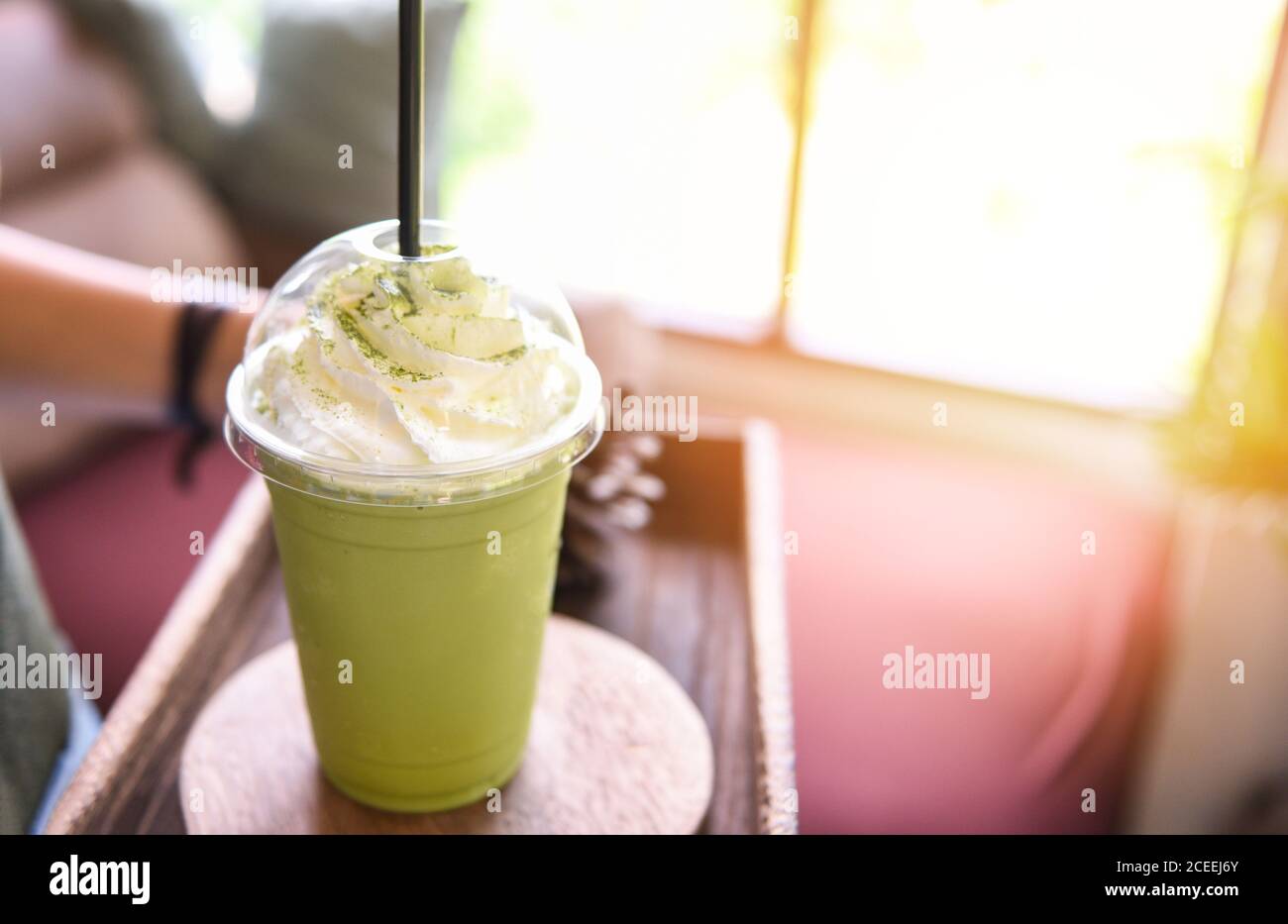 Smoothie au thé vert / thé vert Matcha avec du lait verre en plastique servi dans un café Banque D'Images