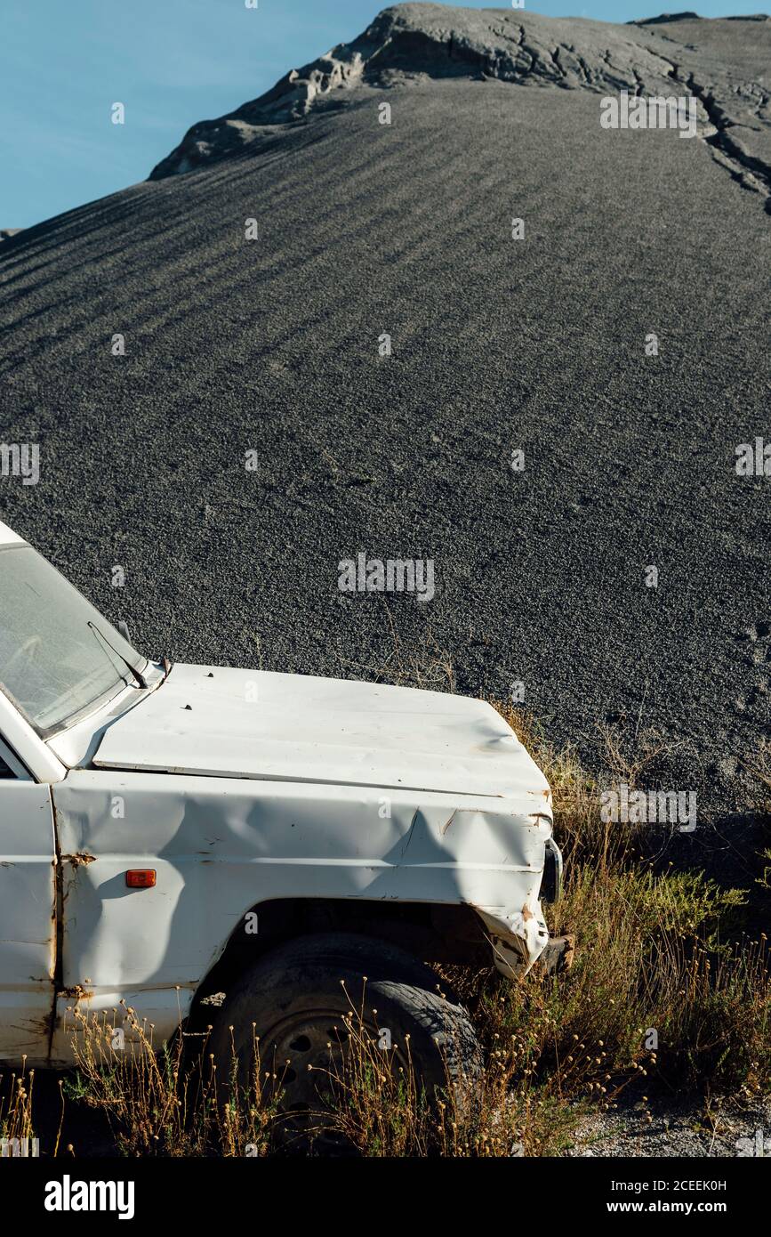 Vieille voiture à proximité d'une pile de gravier noir à un carrière Banque D'Images